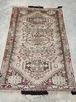 Full view of carpet laid flat showing overall pattern, borders and fringes