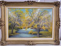 Full view of the framed vintage signed oil painting showing autumn landscape with a river and yellow foliage trees.