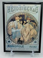 Framed vintage Alphonse Mucha Art Nouveau print of three people drinking champagne with detailed decorative border and text.
