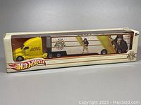 View of full sealed box showing yellow cab with AC/DC logo and trailer with Angus Young and AC/DC High Voltage graphics.