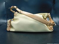 Side view of the nude textured nylon handbag with faux crocodile leather strap and side zippered pocket