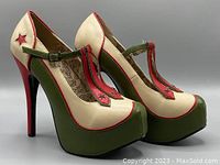 Pair of high heeled pumps angled showing side, toe platform, and T-strap design with multi-colored cream, green and red military theme.
