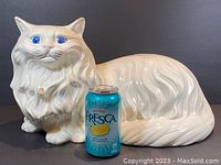Full side view of the large white ceramic cat with Fresca soda can for scale