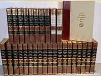 Full set of Funk & Wagnalls New Encyclopedia volumes 1-25, two dictionary volumes, and the World Atlas volume arranged on a shelf showing spine details.