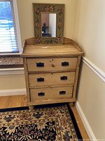 Frontal view of pine three-drawer chest with black metal pulls and raised gallery top.