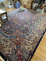 Overall view of the rug on hardwood floor with measuring tape