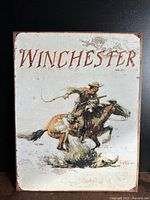 Front view of the tin Winchester sign showing the complete image and text.