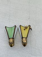 Photo of two Tiffany style stained glass night lights with brass switch bases. Cat figurines perched on top of the glass panels. One cat missing tail.