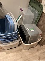 Photo showing stacked plastic containers and green step ladder in background