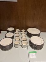 All pieces arranged showing stacks of plates and cups on table