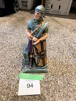 Front view of ceramic figurine showing Roman centurion with spear and shield on rectangular base