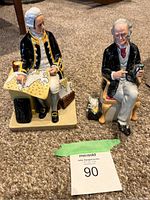 Both figurines front view on carpet with lot tag