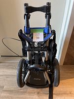 Folded BagBoy Compact 600 golf cart front view showing carrying strap and wheels.