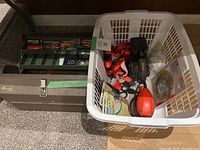 Overview of the toolbox, hand sanders, sandpaper discs and sheets in a laundry basket