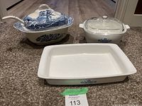 All items together showing blue and white Woodland pattern covered serving bowl with bamboo-style handle, and two white CorningWare casserole dishes with blue cornflower pattern and glass lids.