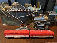 Metal model train bookends and small model trains including red painted engines and silver-toned locomotives