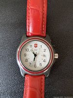 Close-up of the watch face and part of the strap showing Swiss Army logo and second hand.