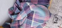 Photo showing the full texture and pattern of the blanket with mauve, blue, pink, and cream plaid colors.