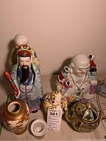 Overall view of lot including two figurines, two jars, a vase, and a teapot