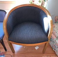 Front angled view of light wood bentwood bucket chair showing dark upholstered seat and backrest with light natural wood frame.