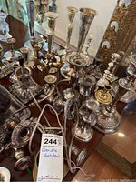 Overview of assorted metal candle holders and brass reindeer on table