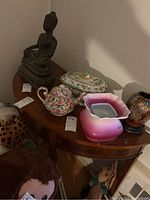 View showing demilune wooden table top with decorative elements and assorted decorative items on top.