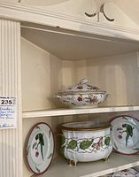 Overall shelf view showing covered serving dish, cachepot and two salad plates