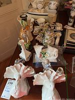 Photo of collection including white porcelain doves, floral decor, and colorful leopard candlestick (not included).