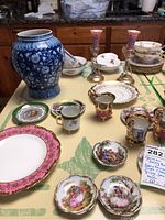 Porcelain items with berry bowls, demitasse cups, small plates and candlestick holders arranged on table