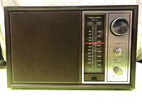 Front view of vintage Realistic MTA-11 AM/FM radio showing speaker grill and control panel with tuning dial, tone and volume knobs.