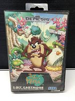 Front of original Sega Genesis Taz-Mania game case with colorful illustrated artwork of Taz in jungle scene