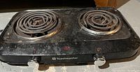 Black Toastmaster 2 burner electric hot plate with coil burners and control knobs on front