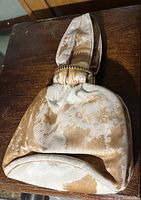 Side angle showing the full purse with cowhide pattern and metal frame closure