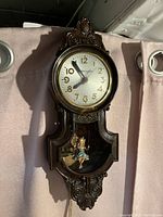 Front view of vintage Mastercrafters bakelite wall clock showing ornate carvings and clock face