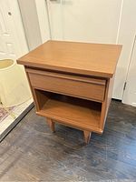 Front and side angle view of the nightstand showing drawer and legs