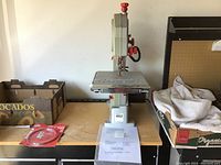 Front view of Craftsman band saw showing its size and build, placed on a wooden table with some other items beside it.