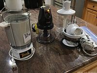Photo of Ninja mini chopper, Tater Twister potato masher blender attachment, and base unit on countertop.