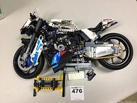 Side view showing whole motorcycle model lying on its side with missing parts visible.