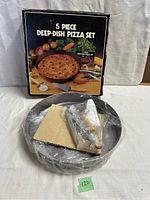 Photo showing the 5 piece deep-dish pizza set box with the contents including wrapped pizza pan and accessories inside the pan.