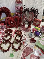 Photo showing assorted Valentine's Day decor including heart wreaths, berry picks, favor bags, and heart props.