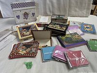 Overview of multiple boxed and loose note card sets with envelopes on a white cloth background.