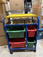 Front view of teacher cart with yellow top and colorful storage bins inside