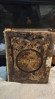 Front cover of heavily used 1890 Holy Bible with embossed leather and gold lettering.