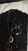 Full view of all pieces including necklace, bracelet, earrings and toe rings on black display pad