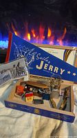 Overview of the lot showing the Davy Crockett glass in box, multiple Zippo lighters, knives, and Sailor Jerry Spiced Rum banner