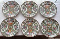 Six Rose Medallion porcelain dinner plates arranged in two rows of three on a tabletop