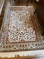 Ivory background scatter rug with dense floral vine pattern and fringe