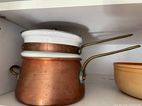 Copper double boiler with white porcelain insert and brass handles, lid included