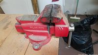 Full side view of the red Craftsman bench vice mounted on a wooden surface. Model number 391-5180 visible on the side.