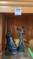 Two Mahogany Princess figurines displayed on a glass shelf, showing detailed design and size difference